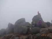 山頂で雲が晴れるのを待つ登山者達